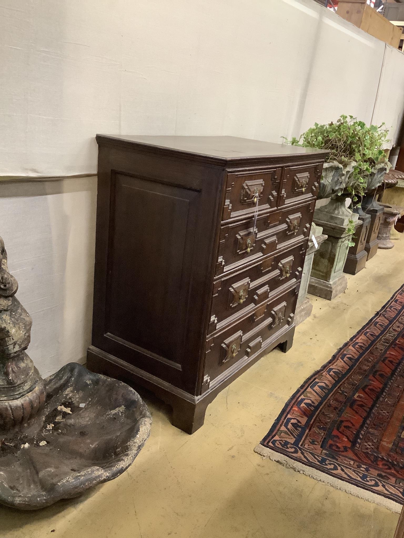 An early 18th century style geometric moulded oak chest of five drawers, width 98cm